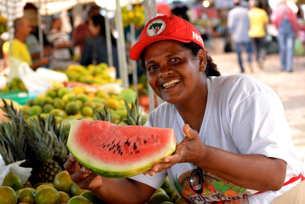 Agricultora com melancia em feira da reforma agrária em Sergipe