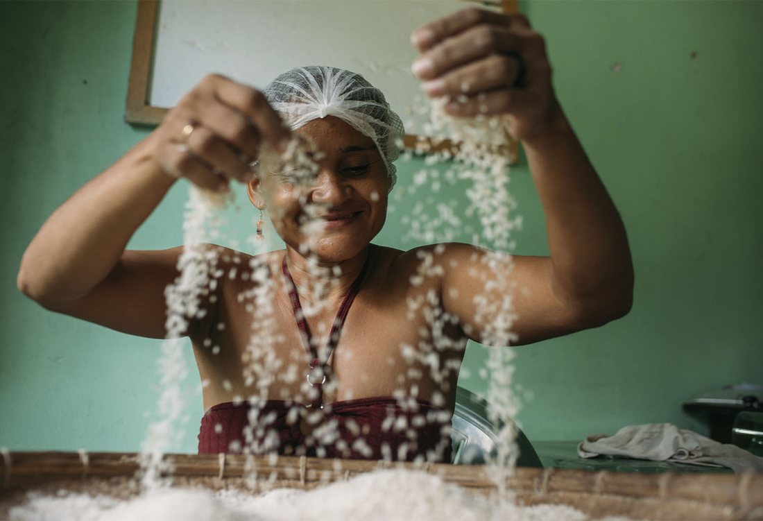 Mulher agricultora separando grãos colhidos no Maranhão